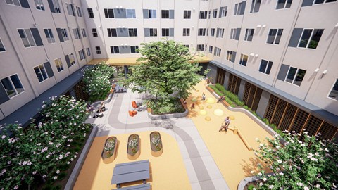 A courtyard with a tree, benches, and a playground.