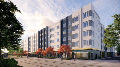 A modern multi-story building with a mix of grey and white exterior and a yellow accent on the ground floor.