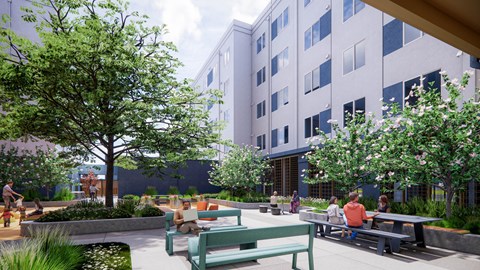A park with people sitting on benches and a tree in the foreground at Rivo Apartments, Sacramento, CA