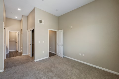 A spacious room with beige walls and carpeted floor.