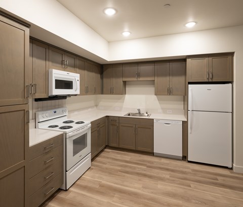 A kitchen with brown cabinets and white appliances.