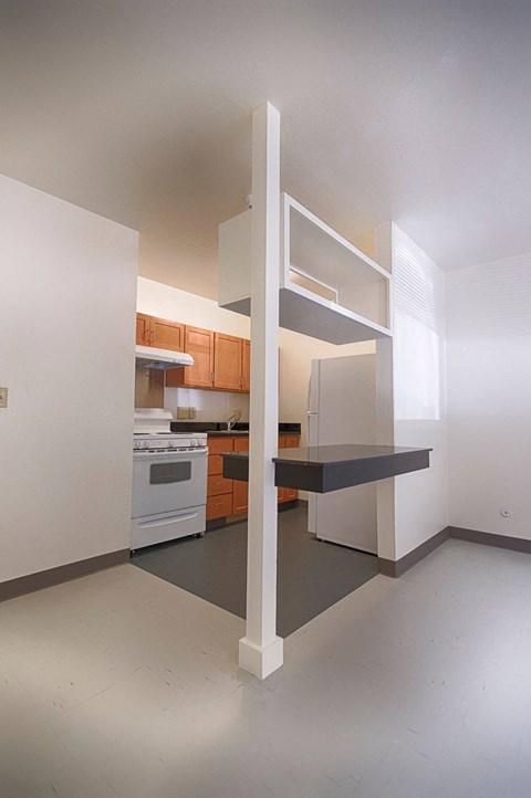 A kitchen with a white wall and a white floor with a white oven and a white fridge.