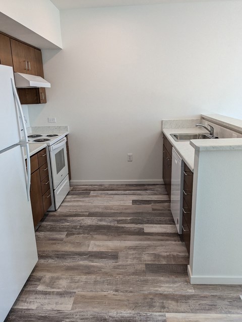 A kitchen with a white refrigerator and wooden cabinets.
