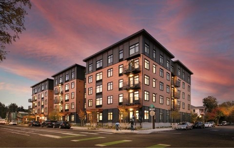 A large apartment building with a parking lot in front.
