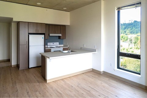 A kitchen with a refrigerator, microwave, and oven.