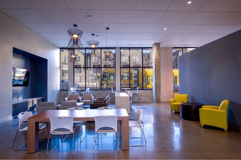 A modern dining room with a long table and chairs.