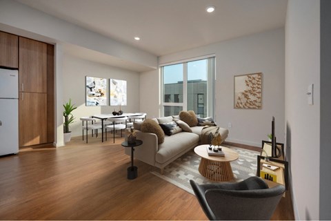 A modern living room with a grey sofa, a wooden coffee table, and a grey armchair.
