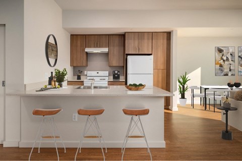 A kitchen with white cabinets and a white island with two stools.