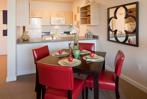 A dining room with a table set for four.