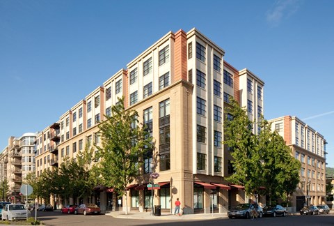 A large building with a red awning sits on a street corner.
