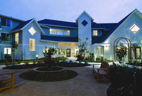 A modern house with a courtyard and a fountain in the middle.