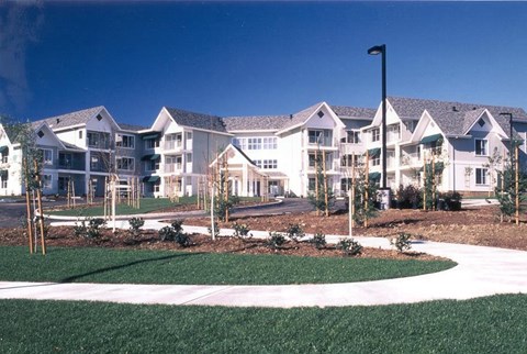 A large white building with a black flag pole in front.