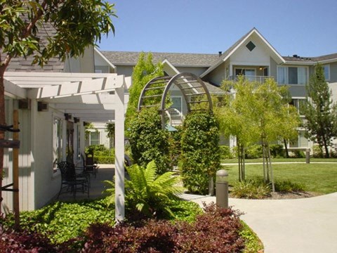 A white building with a green lawn in front.