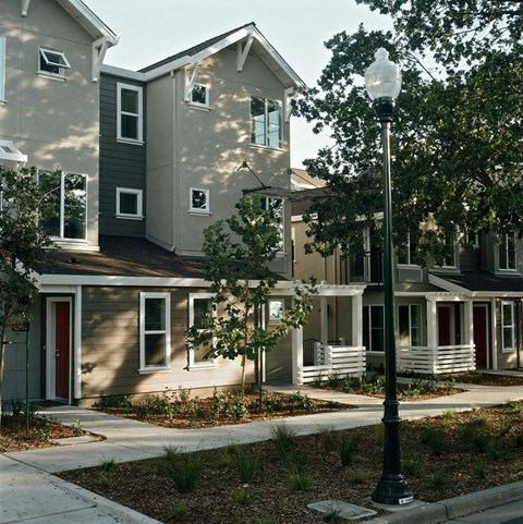 A street lamp stands in front of a house with a red door.
