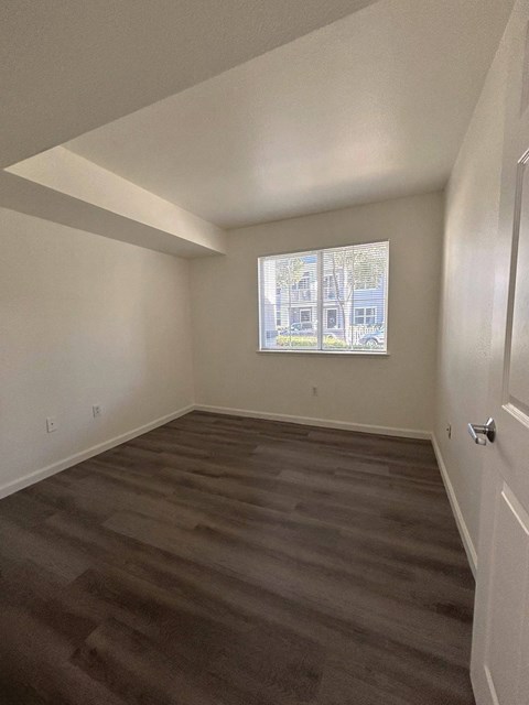 A room with a window showing a view of a building outside.