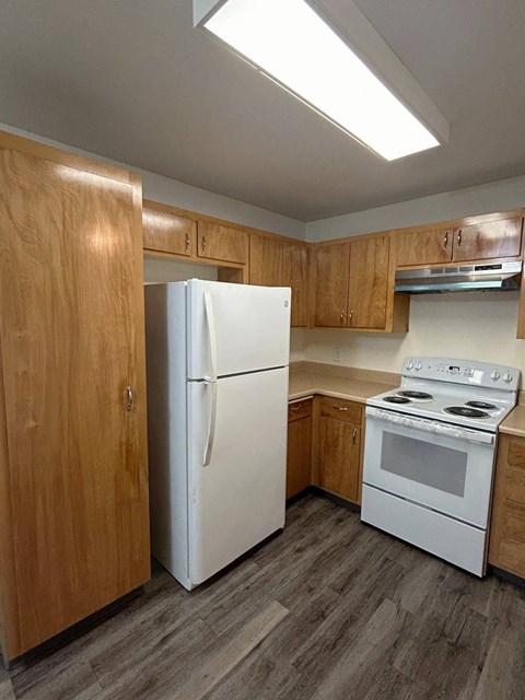 A kitchen with a white refrigerator and a white stove top oven.