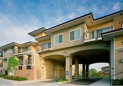 A large apartment complex with a covered walkway connecting the buildings.