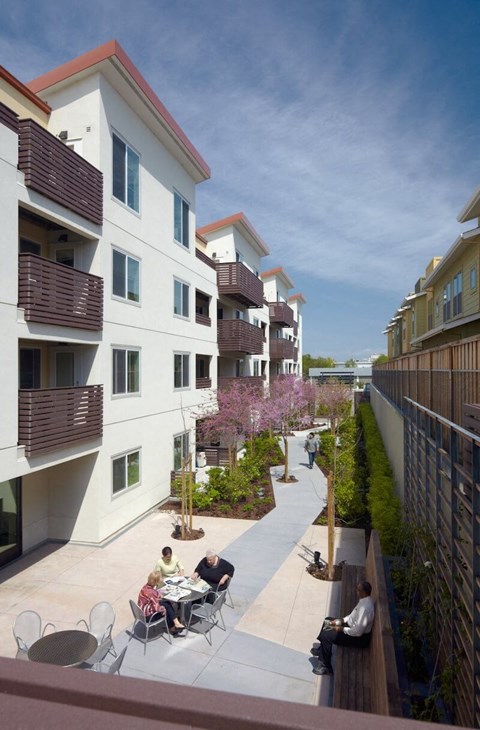A group of people are sitting around a table on a patio.