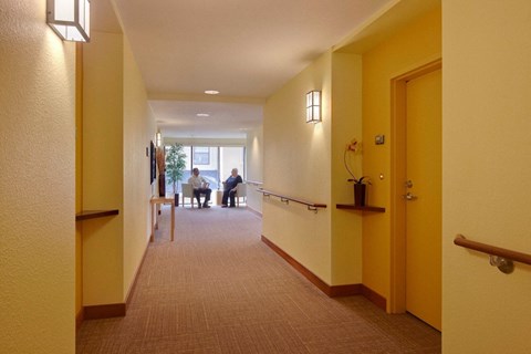 A hallway with people sitting at a table in the distance.