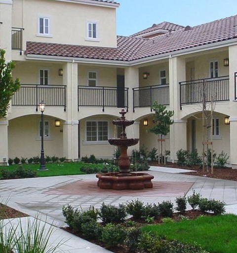 A courtyard with a fountain in the middle of it.