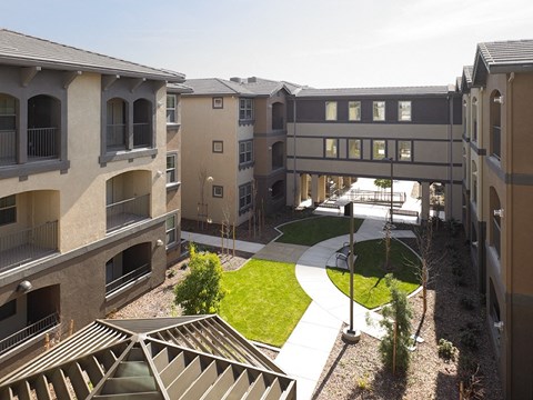 Apartment complex with a green space in the middle.