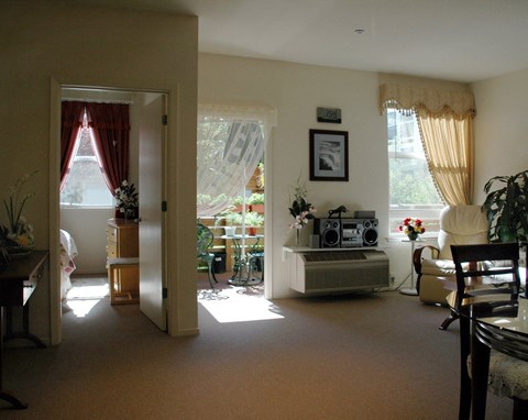 A living room with a brown carpet and a white wall.