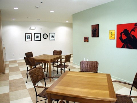 A room with a table and chairs and pictures on the wall.