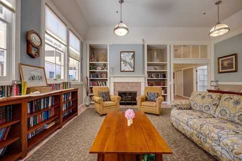 A living room with a fireplace, bookshelves, and a couch.
