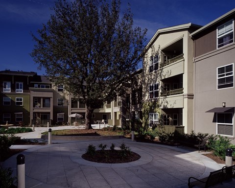 A courtyard surrounded by apartment buildings on a sunny day.