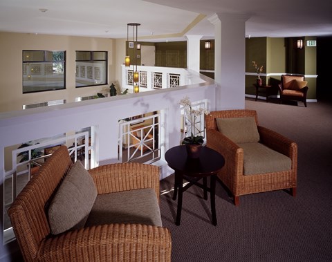 Two brown wicker chairs and a table in a room.