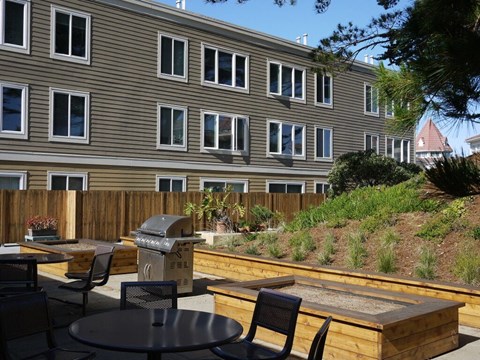 A patio with a table and chairs is in front of a building.