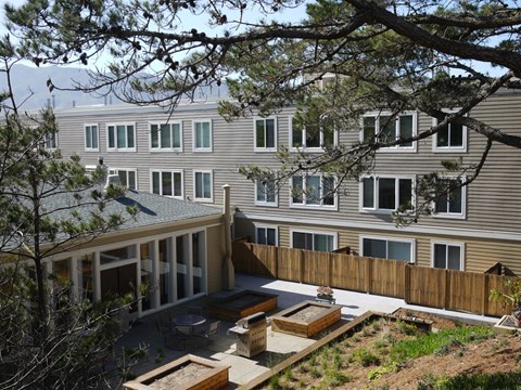 A view of a backyard with a wooden deck and a fence.