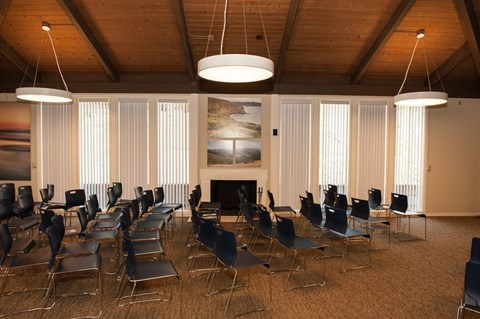 A room with a fireplace and chairs.