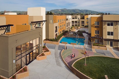 Apartment complex with a pool and a view of the mountains.