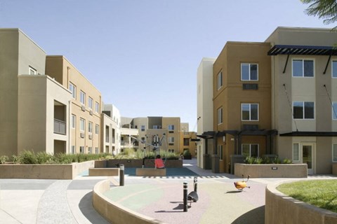 A playground area in front of apartment buildings.