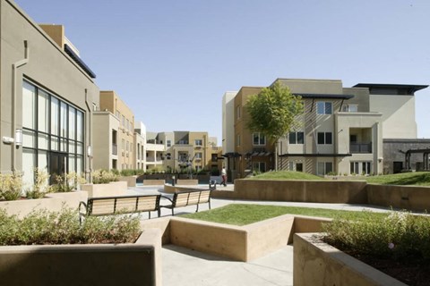 A modern building complex with a courtyard in the foreground.