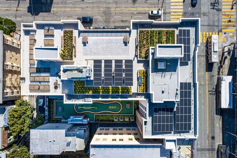 A modern building with a green roof and a large courtyard.