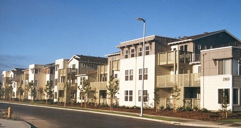 Apartment buildings are lined up along a street.