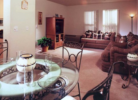 A living room with a glass table and chairs.
