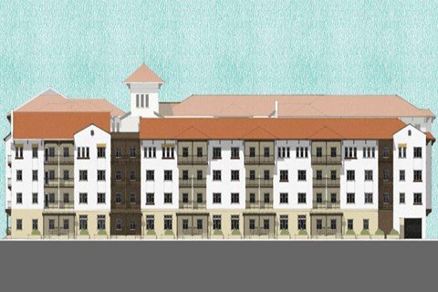 A building with a brown roof and white walls with a tower on top.