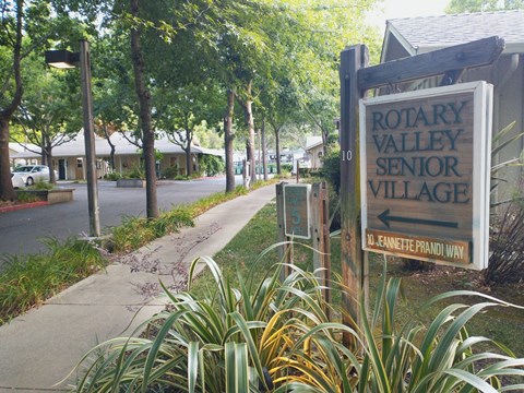 A sign for Rotary Valley Senior Village is in front of a building.