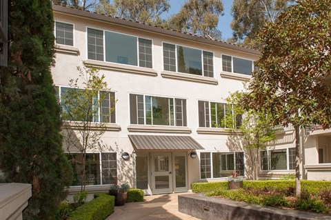 A white building with a brown roof and a glass door.