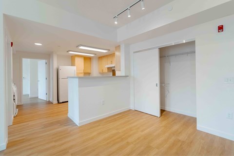 A spacious, empty room with wooden floors and white walls.