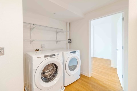 Two white front loading washing machines in a laundry room.