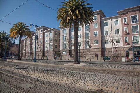 A street with a tram track in the foreground and a building in the background.