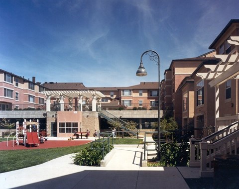 A courtyard with a lamp post and a building in the background.