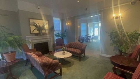A living room with a fireplace and a painting on the wall.