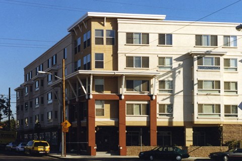 A multi-story building with a parking lot in front.
