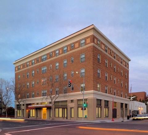 A large red brick building with a flat roof and a row of windows on the ground floor.