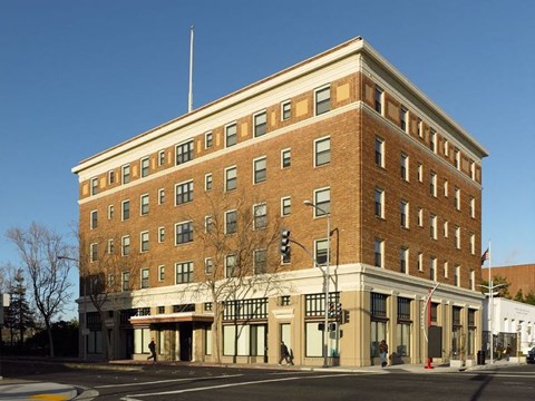A large brick building with a flat roof and a flag on the right side.